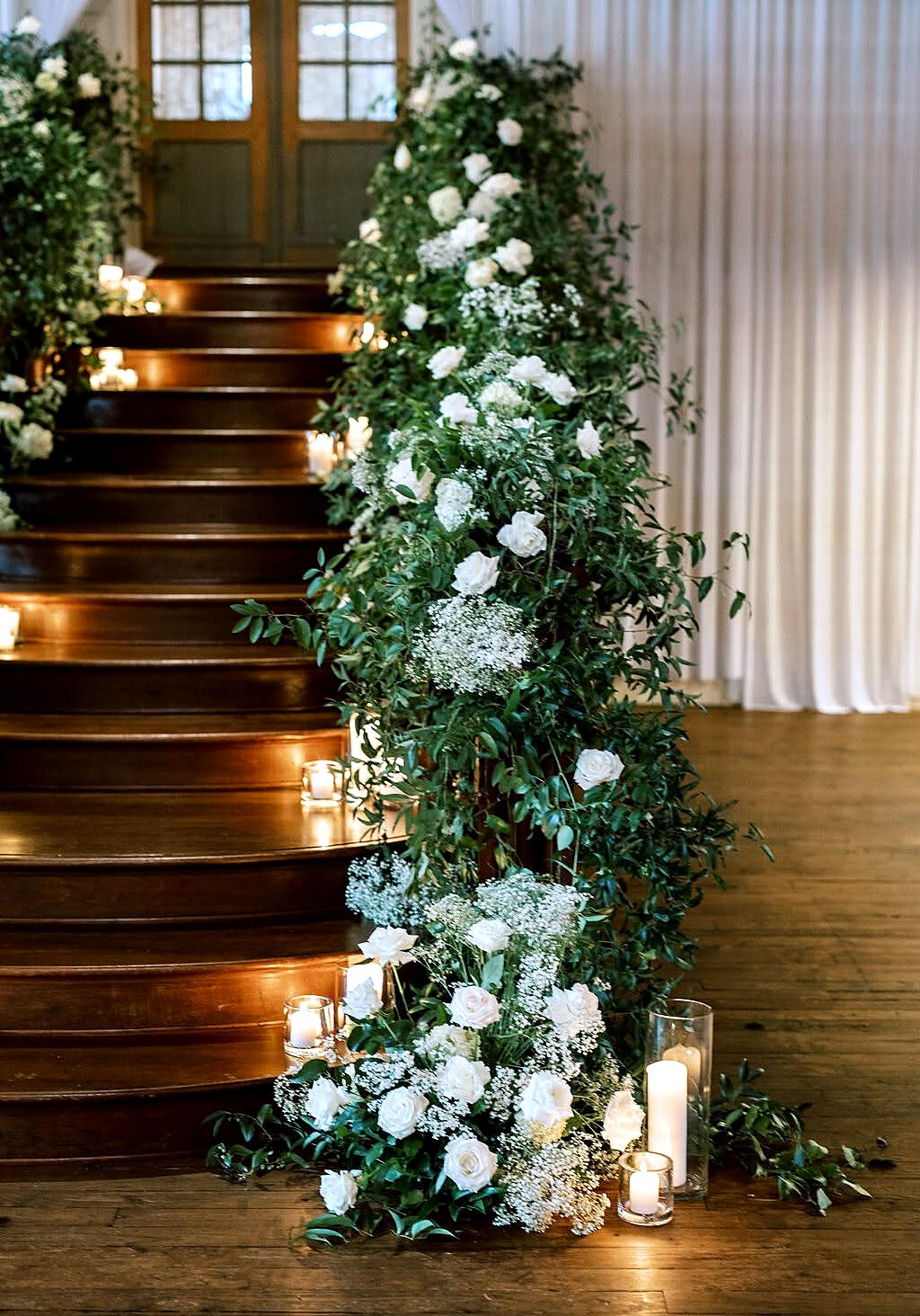 Candlelit staircase garland with lush greenery
